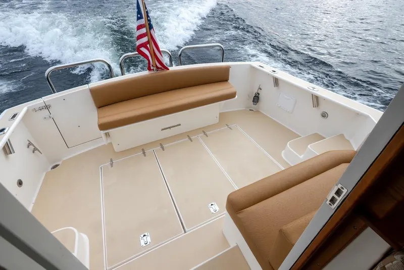 Slide: The Image of 2007 Bruckmann BLUESTAR boat deck with seating, American flag, and ocean view. - 24