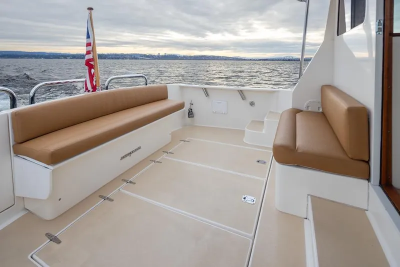 Slide: The Image of 2007 Bruckmann BLUESTAR yacht deck with tan seating, ocean view, and American flag. - 25