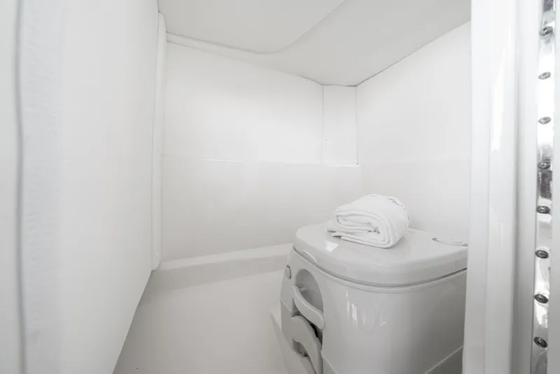 Slide: The Image of 2024 Sea Ray SPX 230 boat interior with compact white bathroom and toilet. - 6