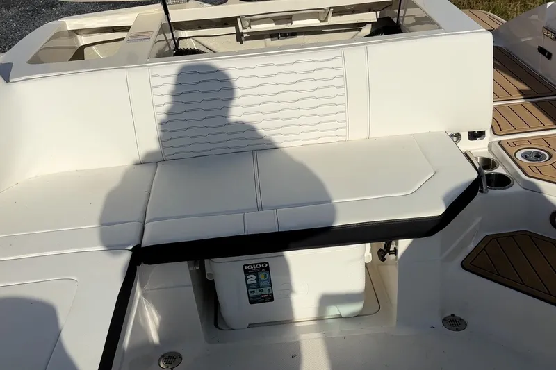 Slide: The Image of 2024 Sea Ray SPX 230 boat interior with white seating and storage compartment. - 9