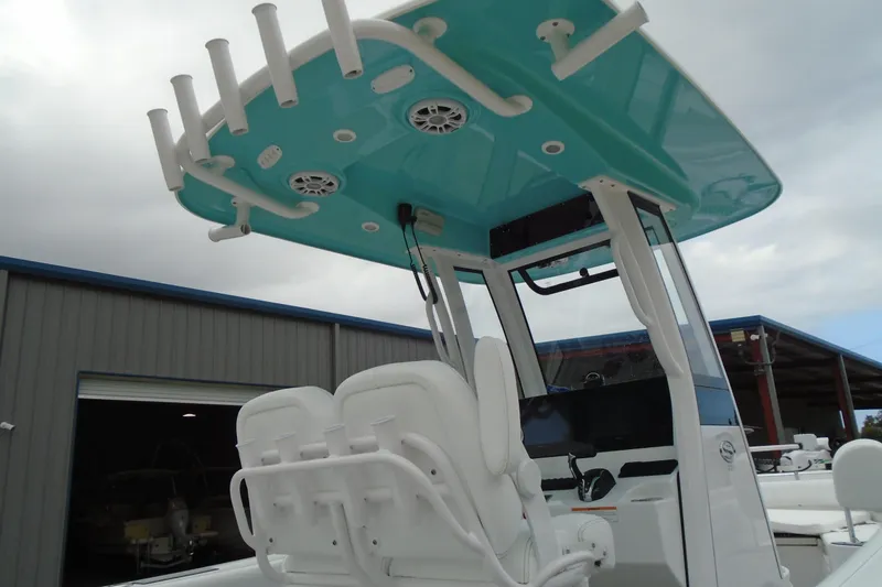 Slide: The Image of 2024 Sportsman Heritage 231 Center Console boat with teal T-top and white seating. - 25