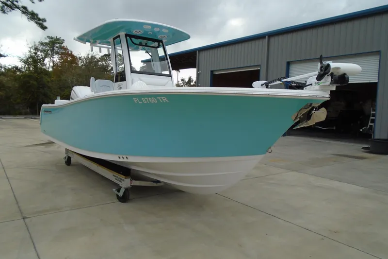 Slide: The Image of 2024 Sportsman Heritage 231 Center Console boat in turquoise, parked outside a warehouse. - 30