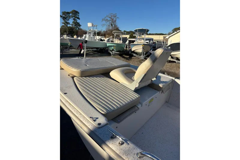 Slide: The Image of 2018 Carolina Skiff 18 JVX CC boat with beige seating, parked outdoors. - 3