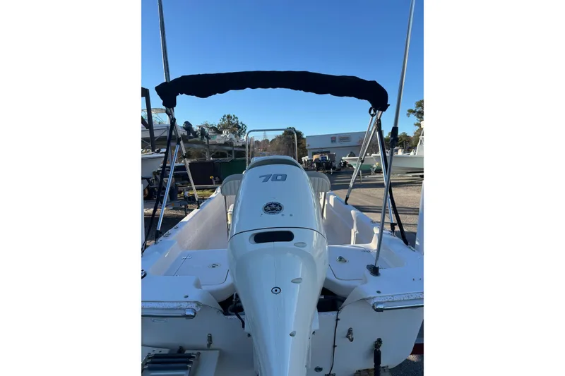 Slide: The Image of 2018 Carolina Skiff 18 JVX CC boat with outboard motor and canopy in a marina. - 6
