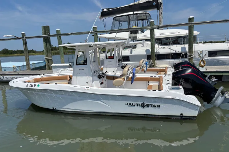The Image of 2025 NauticStar 242L Offshore boat docked in marina, featuring dual engines. - 1