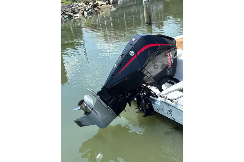 Slide: The Image of 2025 NauticStar 242L Offshore boat with powerful outboard motor in water. - 10