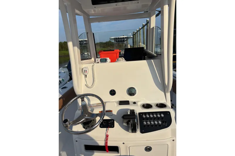 Slide: The Image of 2025 NauticStar 242L Offshore boat console with steering wheel and controls. - 6