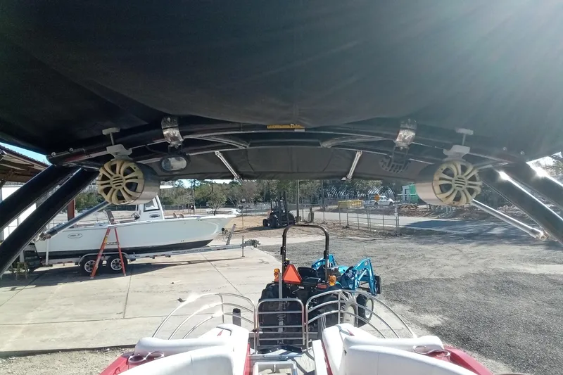 Slide: The Image of 2019 Razor 238 boat interior with speakers and canopy, parked near other boats. - 11