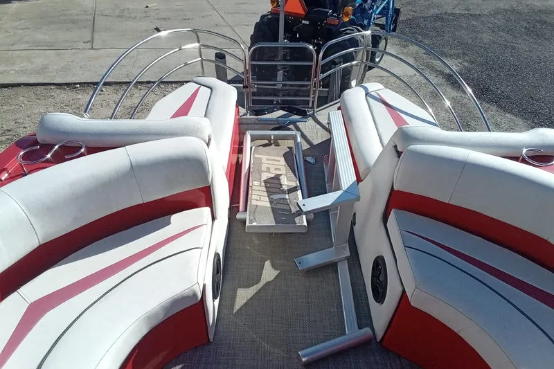 Slide: The Image of 2019 Razor 238 boat interior with red and white seating, docked near a tractor. - 14
