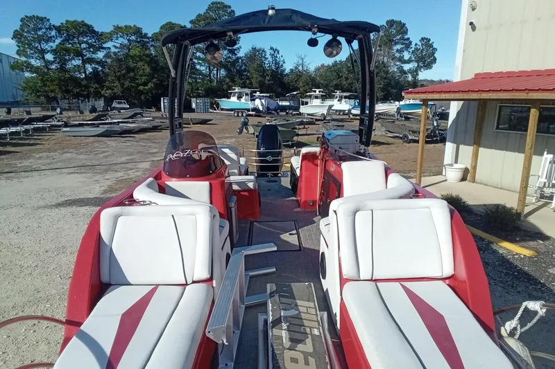 Slide: The Image of 2019 Razor 238 boat with red and white seating, parked outdoors near other boats. - 20