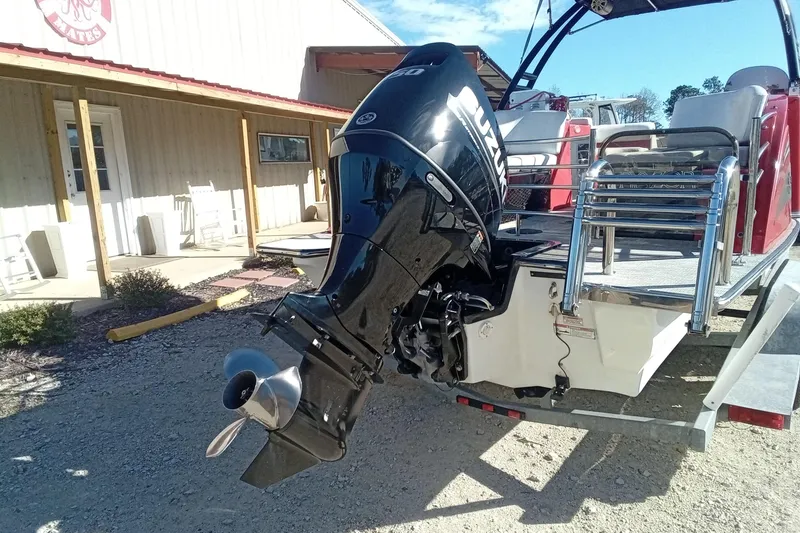 Slide: The Image of 2019 Razor 238 boat with Suzuki outboard motor, parked outside a building. - 5