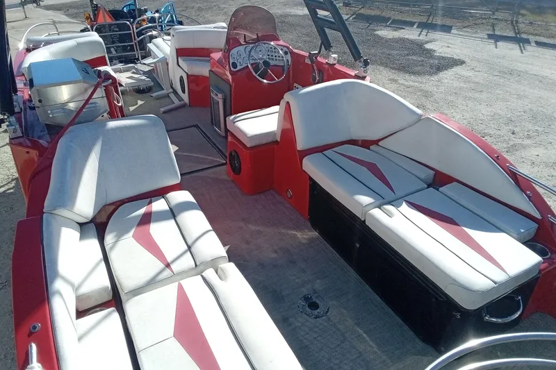 Slide: The Image of Red and white Razor 238 boat interior with seating, steering wheel, and grill, 2019 model. - 7