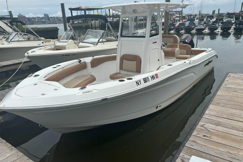Slide: The Image of 2025 NauticStar 242L Offshore boat docked at marina, featuring sleek design and spacious seating. - 3