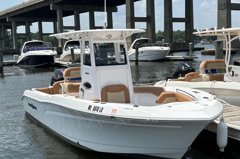 The Image of 2025 NauticStar 242L Offshore boat docked in marina, featuring sleek design and spacious seating. - 1