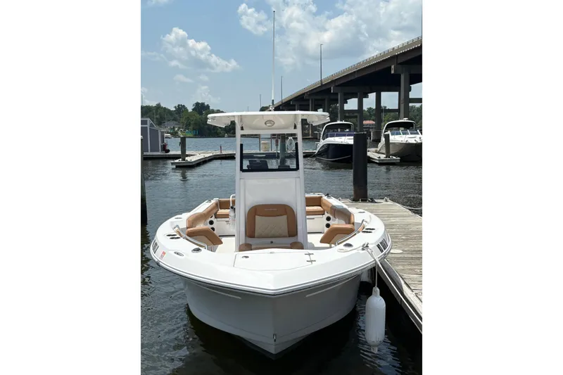 Slide: The Image of 2025 NauticStar 242L Offshore boat docked at marina under clear sky. - 2