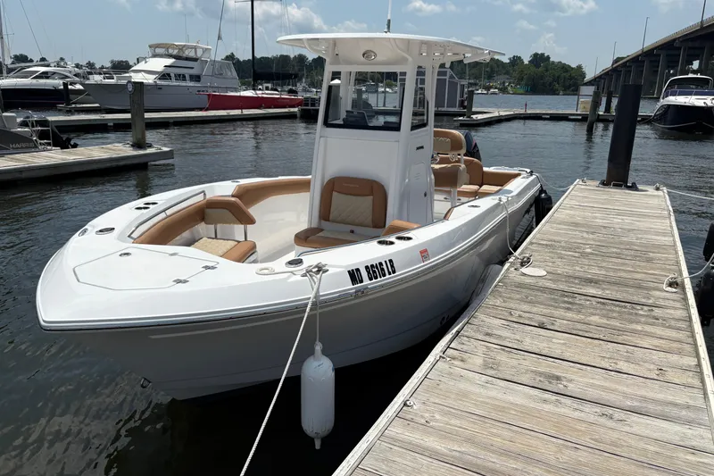 Slide: The Image of 2025 NauticStar 242L Offshore boat docked at marina, featuring sleek design and spacious seating. - 3