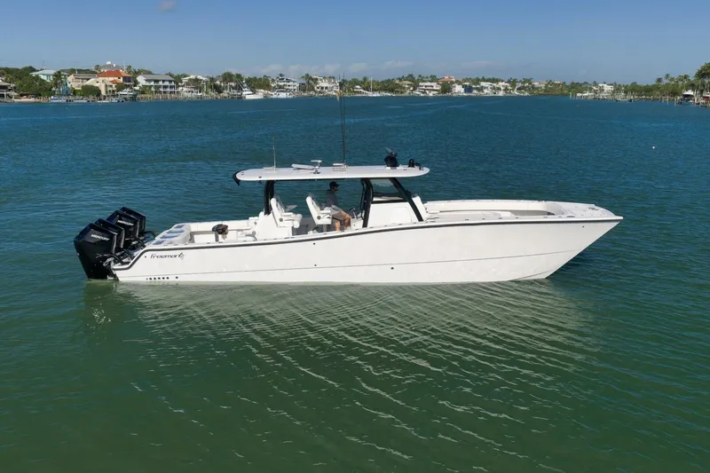 Slide: The Image of 2023 Freeman 43 boat on calm blue water, featuring multiple outboard engines. - 2