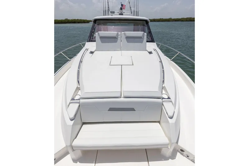 Slide: The Image of Manufacturer Provided Image: 2025 Pursuit OS 445 Offshore boat with spacious deck and seating, on calm water. - 8