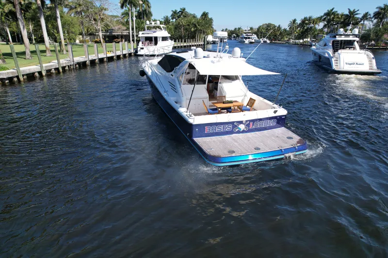 Slide: The Image of 1999 Uniesse 57 Open yacht cruising on a scenic waterway with palm trees. - 15