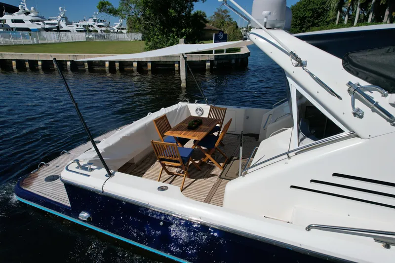 Slide: The Image of Uniesse 57 Open 1999 yacht with outdoor seating on calm water. - 18