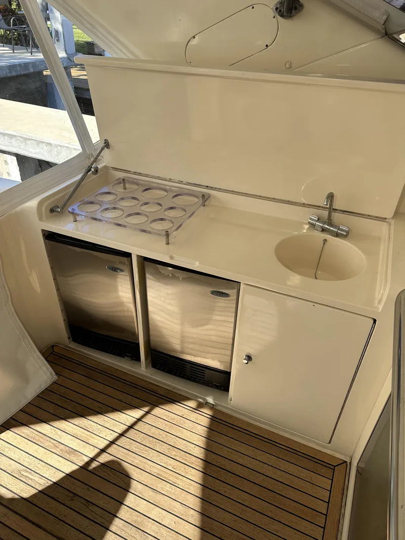 Slide: The Image of Compact kitchenette on a 1999 Uniesse 57 Open yacht with stove, sink, and storage. - 20