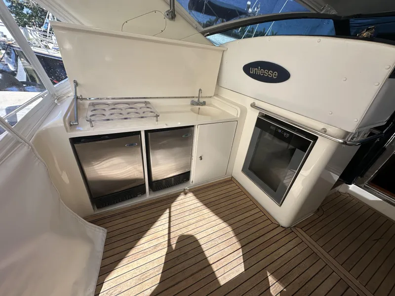Slide: The Image of 1999 Uniesse 57 Open yacht interior with kitchenette and wooden flooring. - 22
