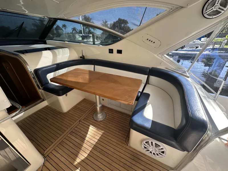Slide: The Image of Luxurious seating area on 1999 Uniesse 57 Open yacht with wooden table and leather upholstery. - 24