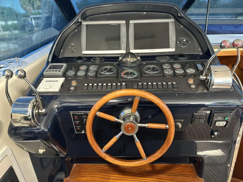 Slide: The Image of Cockpit of 1999 Uniesse 57 Open yacht with wooden steering wheel and navigation controls. - 29