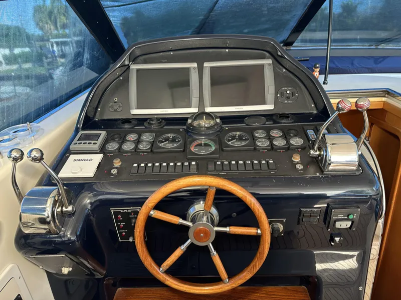 Slide: The Image of Control panel of a 1999 Uniesse 57 Open yacht with wooden steering wheel. - 31