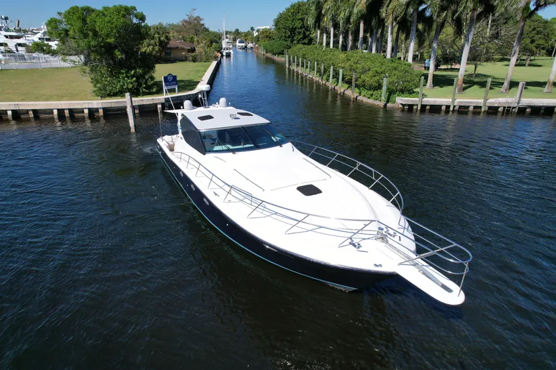 Slide: The Image of Uniesse 57 Open 1999 yacht cruising on a scenic waterway with lush greenery. - 4