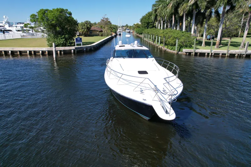 Slide: The Image of 1999 Uniesse 57 Open yacht cruising in a scenic canal with lush greenery. - 5
