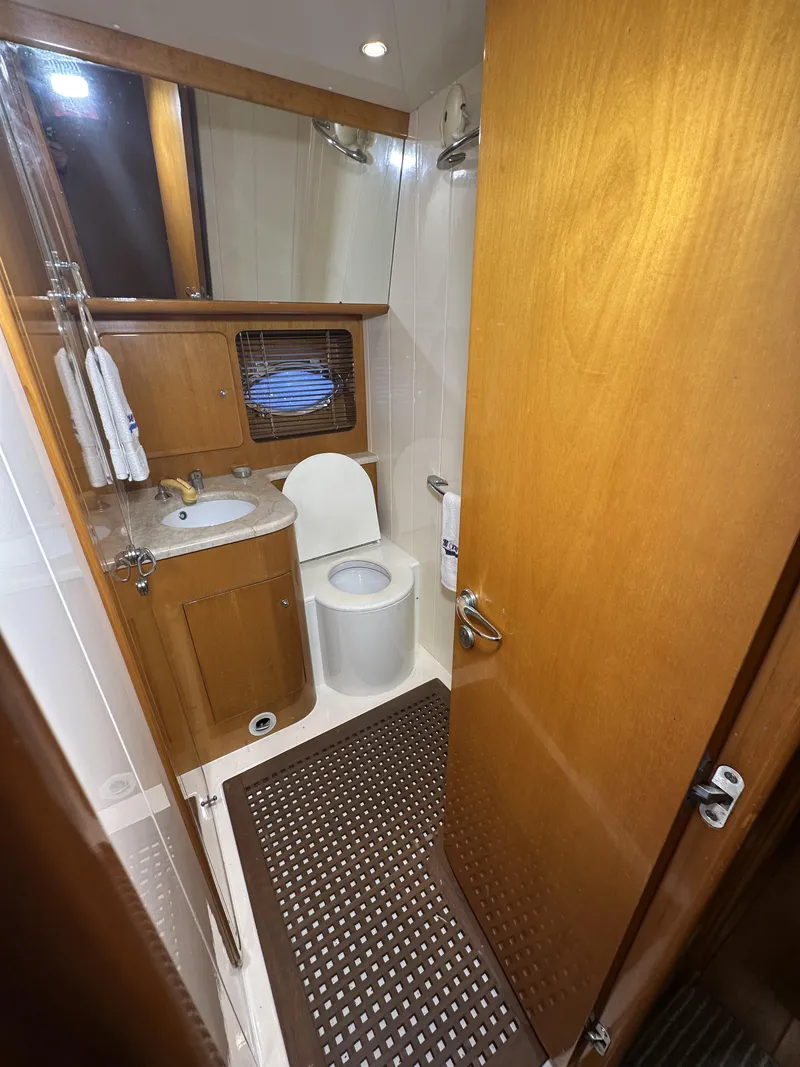 Slide: The Image of Bathroom interior of 1999 Uniesse 57 Open yacht, featuring wooden cabinetry and modern fixtures. - 50