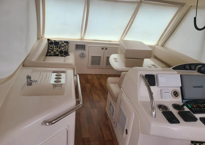 Slide: The Image of Interior of 2009 Riviera 47 Enclosed Flybridge Series II with helm and seating area. - 43