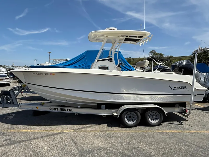 The Image of 2019 Boston Whaler 230 Outrage boat on a Continental trailer, parked outdoors. - 0