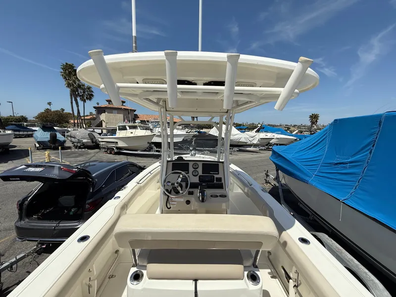 Slide: The Image of 2019 Boston Whaler 230 Outrage boat at marina, featuring center console and T-top. - 14