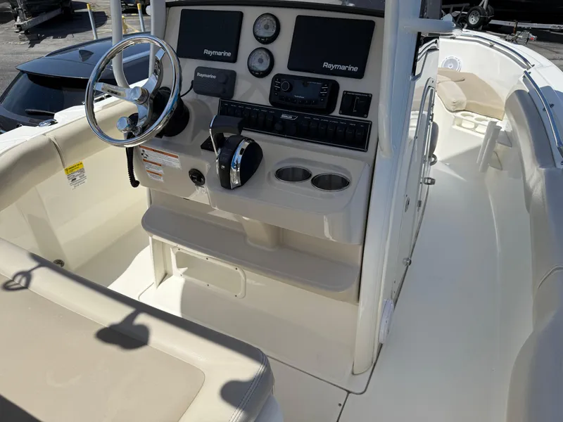 Slide: The Image of 2019 Boston Whaler 230 Outrage boat cockpit with steering wheel and control panel. - 17