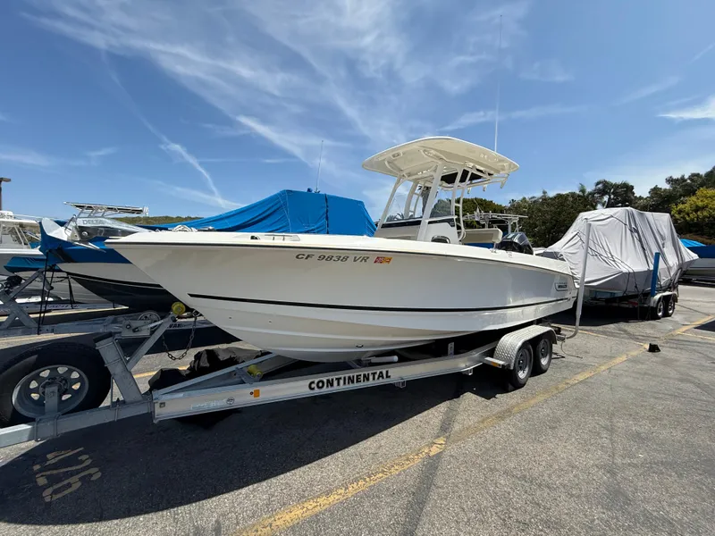 Slide: The Image of 2019 Boston Whaler 230 Outrage boat on trailer in sunny marina setting. - 2