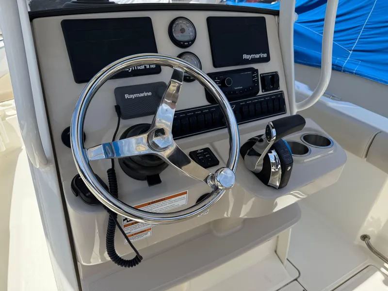 Slide: The Image of Control panel of a 2019 Boston Whaler 230 Outrage boat with steering wheel and Raymarine electronics. - 20