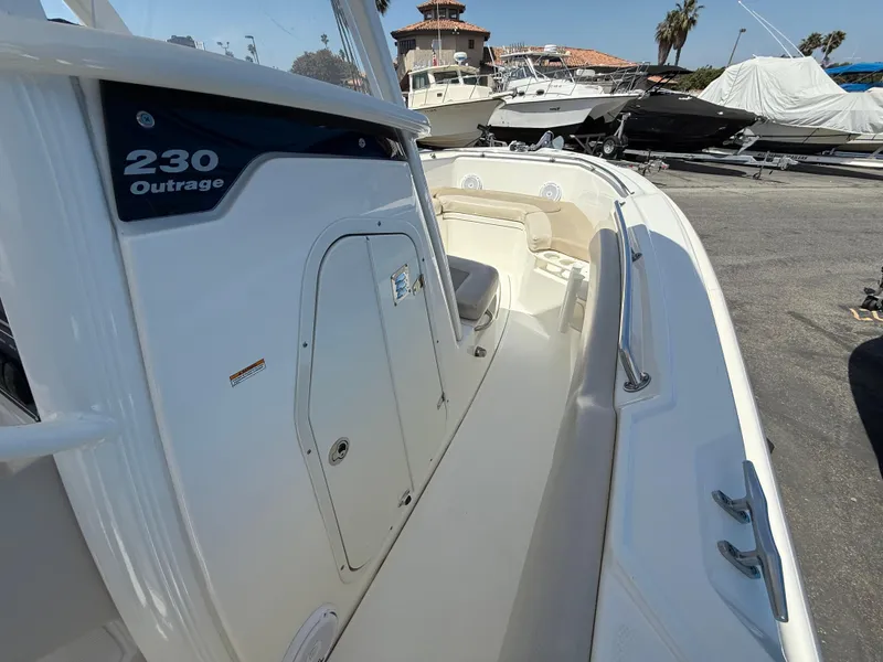 Slide: The Image of 2019 Boston Whaler 230 Outrage boat, docked, showcasing sleek design and spacious deck. - 22