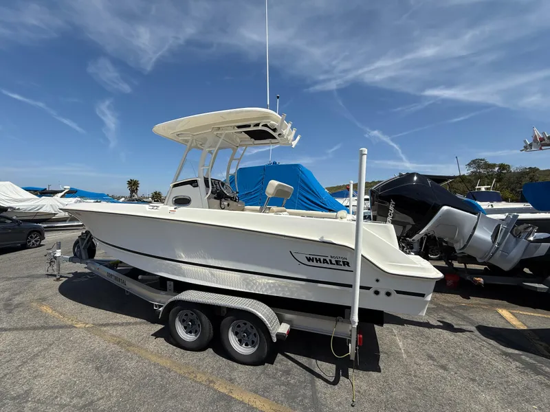 Slide: The Image of 2019 Boston Whaler 230 Outrage boat on trailer under clear sky. - 3