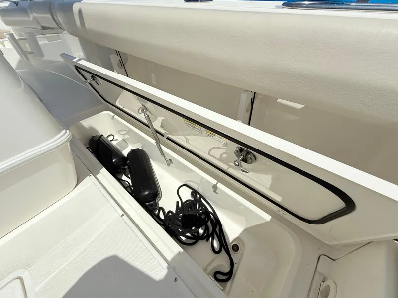 Slide: The Image of Open storage compartment on 2019 Boston Whaler 230 Outrage boat, showing equipment inside. - 30