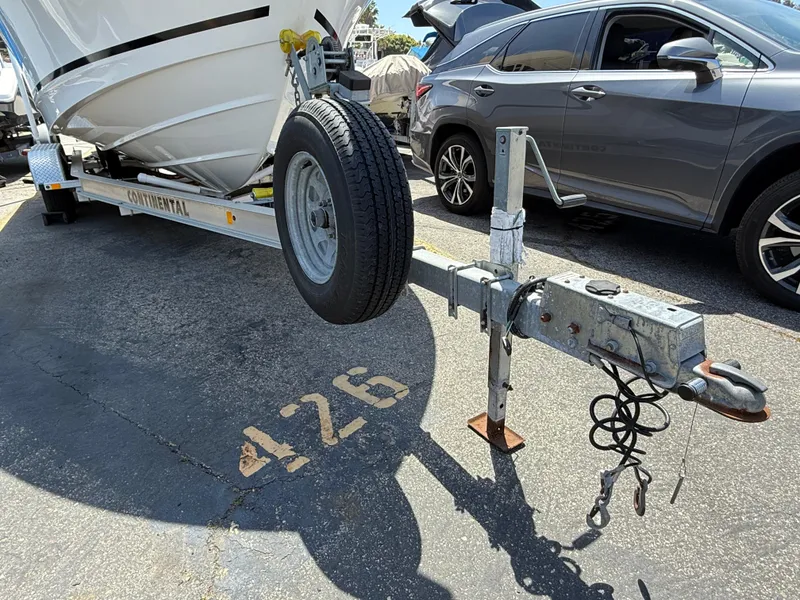 Slide: The Image of 2019 Boston Whaler 230 Outrage on trailer, parked in lot, next to a car. - 34