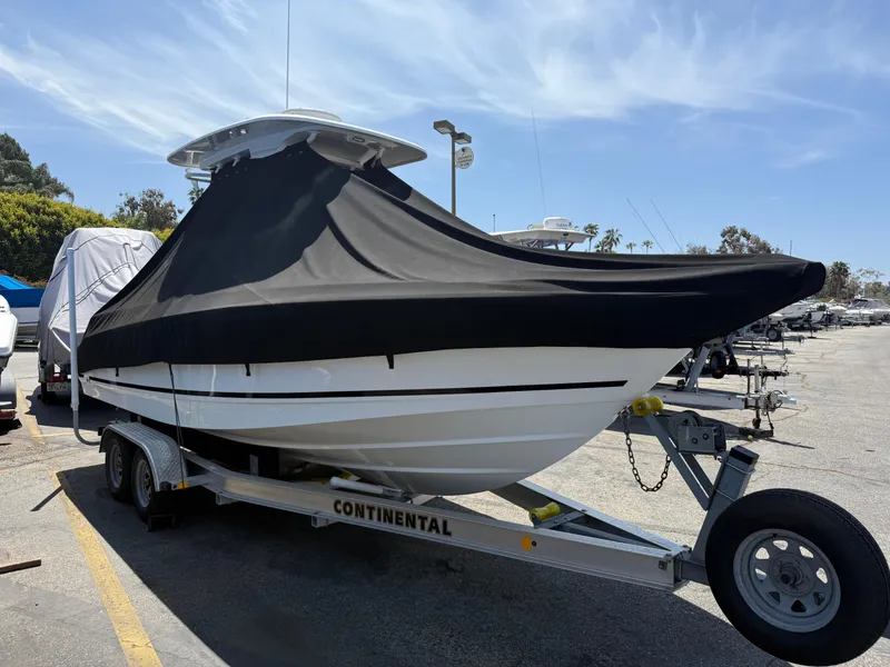 Slide: The Image of 2019 Boston Whaler 230 Outrage boat on trailer, covered, parked outdoors. - 37
