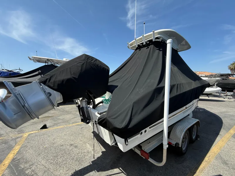 Slide: The Image of 2019 Boston Whaler 230 Outrage boat covered on trailer, parked outdoors. - 38