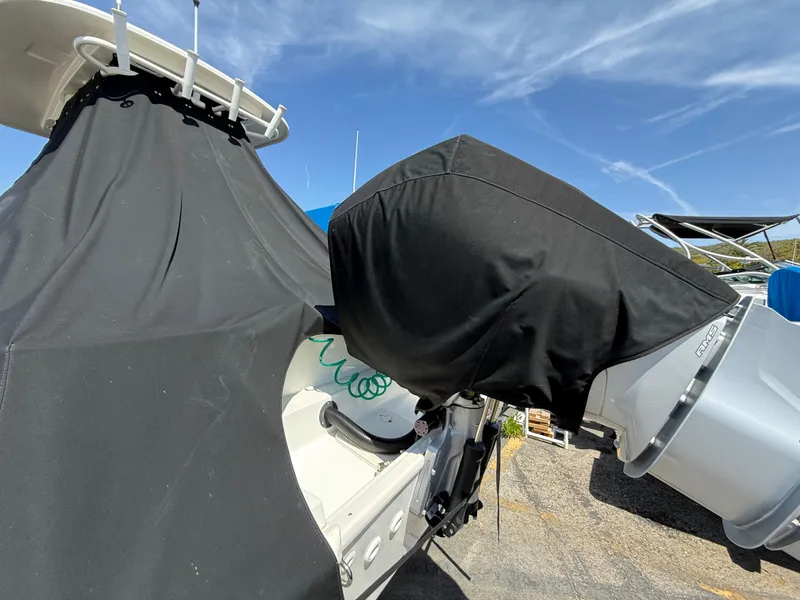 Slide: The Image of 2019 Boston Whaler 230 Outrage with covered outboard motor, parked outdoors. - 40