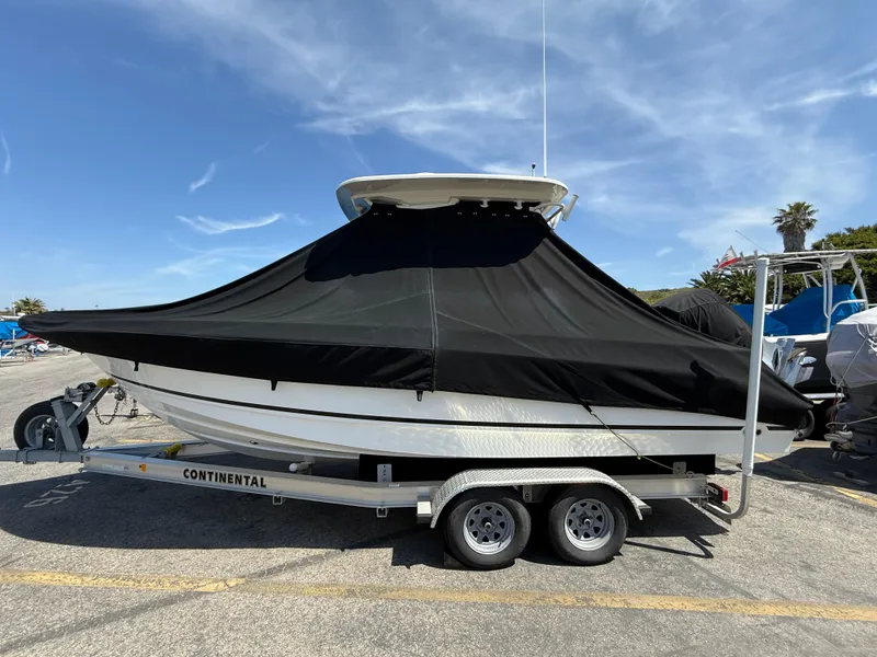 Slide: The Image of 2019 Boston Whaler 230 Outrage boat covered on trailer, parked outdoors. - 41