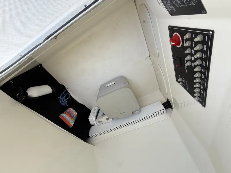 Slide: The Image of 2019 Boston Whaler 230 Outrage interior storage with control panel and equipment. - 43