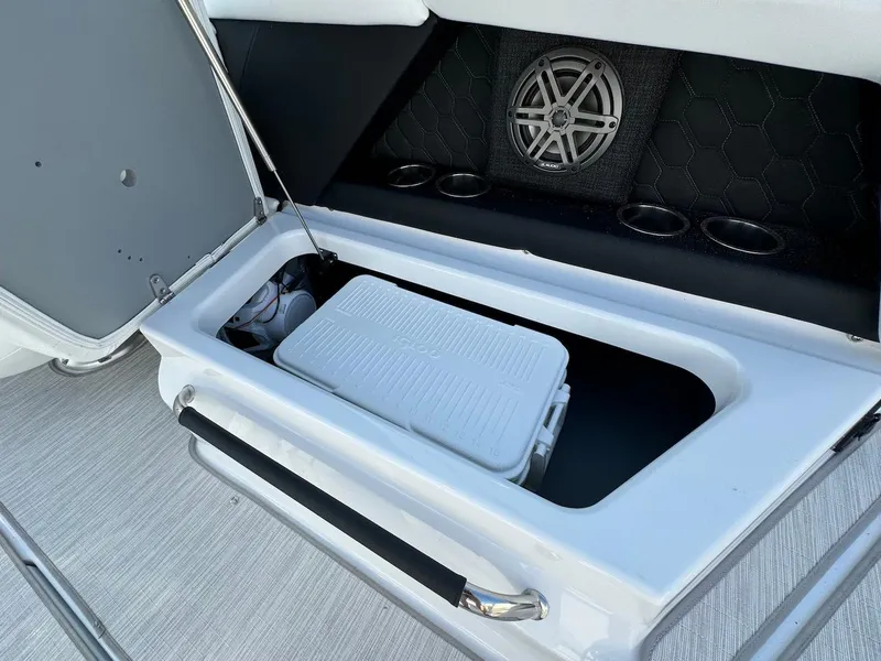 Slide: The Image of 2025 Four Winns H6 OB boat storage compartment with built-in speaker and cooler. - 10