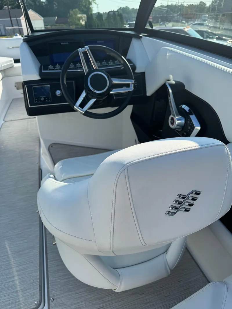 Slide: The Image of 2025 Four Winns H6 OB boat interior with sleek steering and white seating. - 11