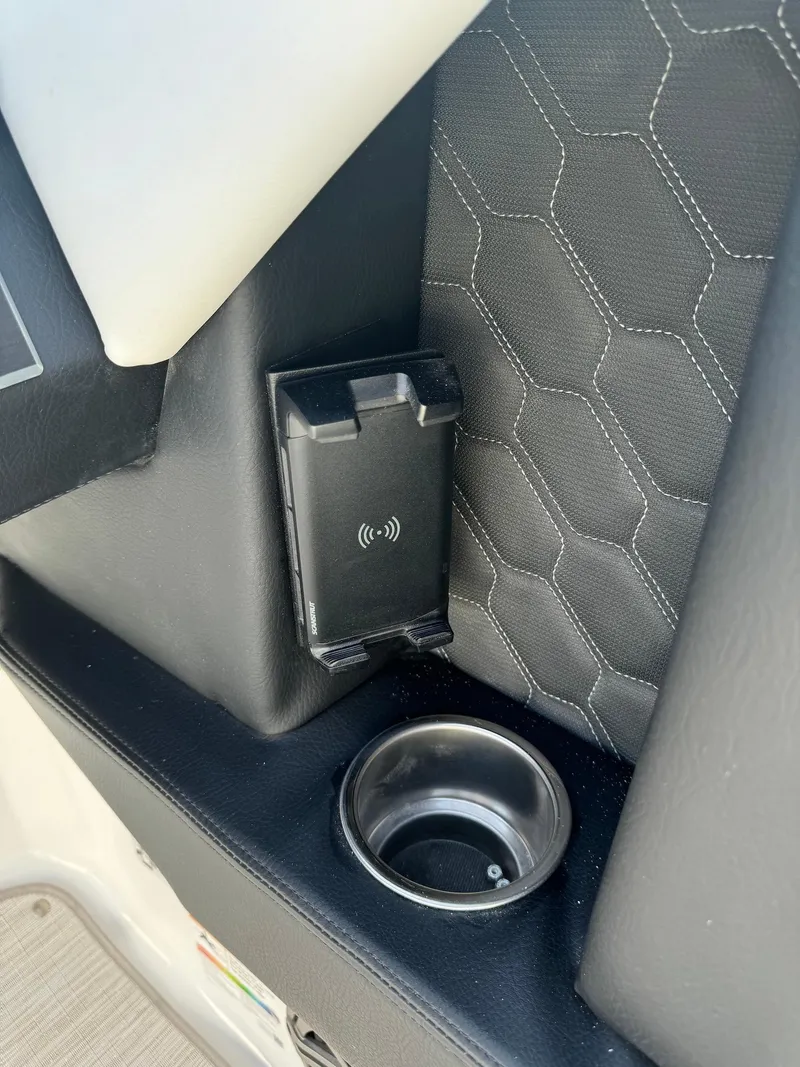 Slide: The Image of 2025 Four Winns H6 OB interior with wireless charger and cup holder. - 13
